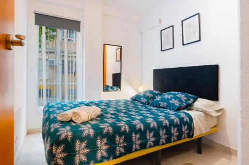 塞维利亚San Pagés 3BR Apartment的一间卧室配有一张带蓝色毯子的床