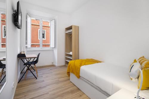 里斯本Smart Living Hub: Designer Spaces for Digital Nomads & Remote Workers的一间卧室配有一张床、一张书桌和一个窗户。