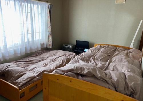 小樽Otaru - House - Vacation STAY 87614的卧室内的一张未铺好的床,设有窗户