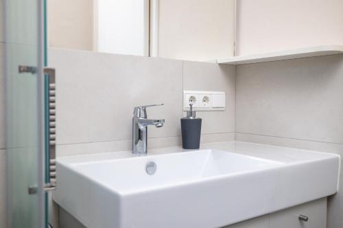 修希Apartment Bellevue Seis的浴室设有白色水槽和镜子