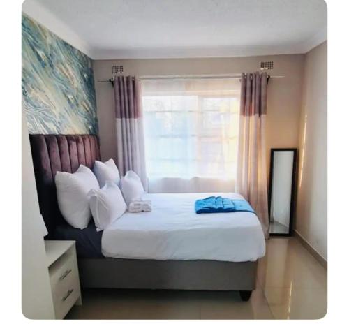 哈拉雷Beautiful 3-Bed House in Harare的一间卧室设有一张大床和窗户