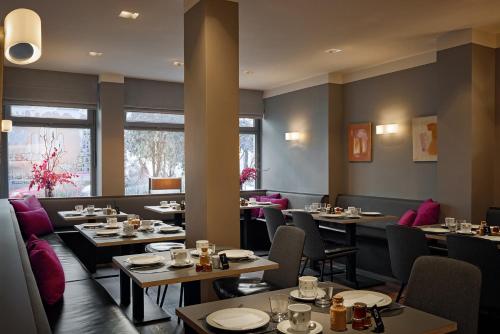 汉堡圣安纳酒店的用餐室设有桌椅和窗户。