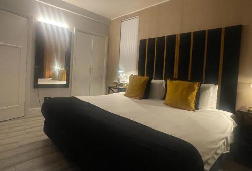 伯明翰Luxury 9ine Lush Jacuzzi Apartment with Balcony的卧室配有一张带黄色枕头的大型白色床。