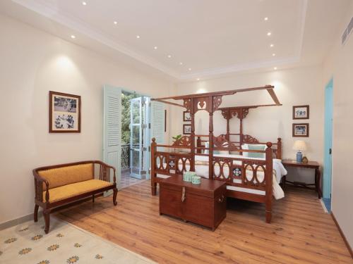蓬蒂切里Villa Kouga的一间卧室配有一张大天蓬床和一把椅子