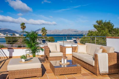 阿尔库迪亚Traumhafte Villa Marisol für 8 Gäste am Meer的一个带柳条家具的庭院,享有水景