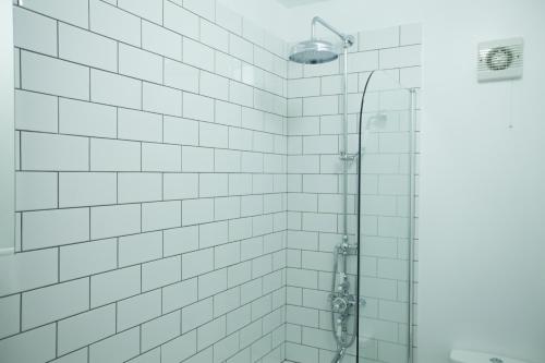 泰晤士河畔里士满里士满摩登公寓旅馆的带淋浴的浴室和白色瓷砖墙壁