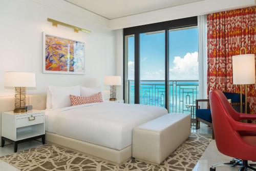 拿骚巴哈马君悦度假村的卧室配有白色的床和红色椅子
