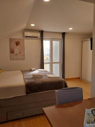 马卡尔斯卡Apartments Rose Loboja的一间卧室设有一张大床和一个窗户。