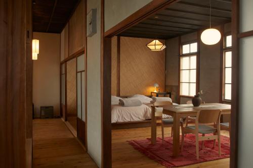 Tamba-sasayamaLhotel de Mai的一间带床和桌子的房间以及一间用餐室