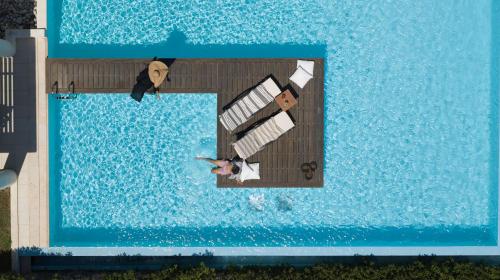 依克希亚The Ixian Grand & All Suites - Adults Only Hotel的站在游泳池码头上的男女