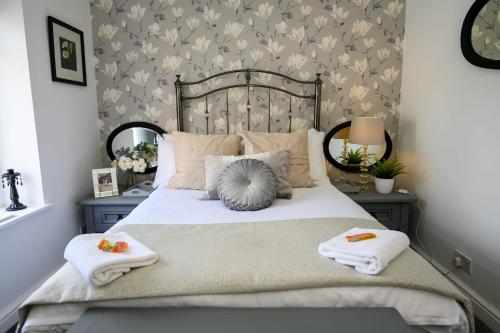阿伯代尔Poet's Cottage by StayStaycations的一间卧室配有一张床,上面有两条毛巾