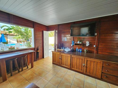 伊列乌斯Pousada Suítes do Atlântico的一个带木墙和平面电视的大厨房