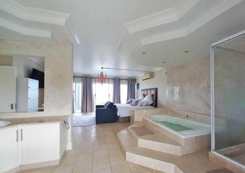 德班Glen Ashley Beach Villas的带浴缸的大浴室和卧室