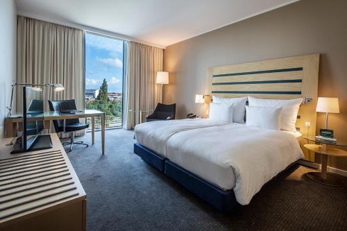 哥本哈根哥本哈根机场克拉里昂酒店的酒店客房设有一张大床和一张书桌。