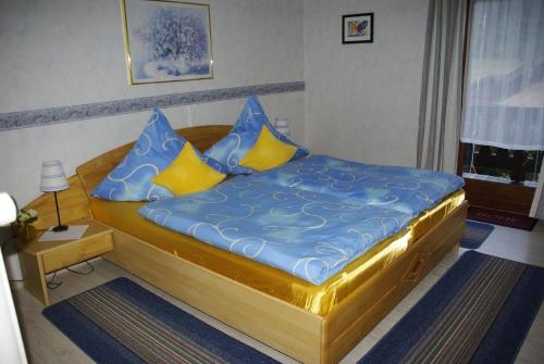 鲁波尔丁Ferienwohnung für 3 Personen in Ruhpolding, Bayern的一间卧室配有蓝色和黄色枕头的床