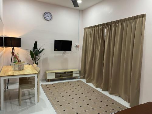 马兰Paktam Ruduwe Homestay的客厅配有桌子、电视和窗帘