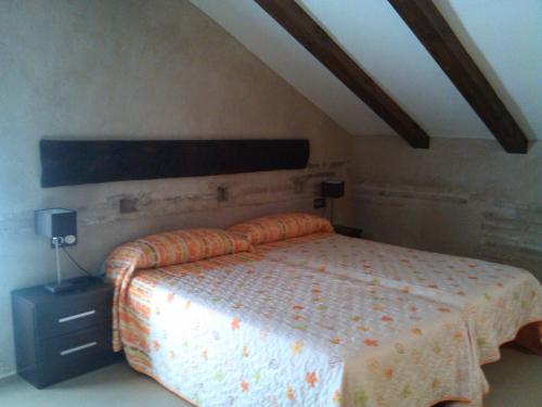 卡索拉Torre Del Inquisidor的一间带一张床铺的卧室,位于带天花板的房间内