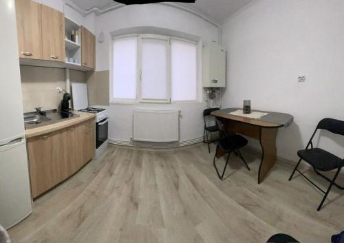 BîrladEnjoy Apartment Barlad的厨房配有桌子和书桌。