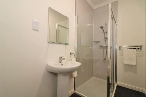 拉纳克Signature - No 1 Bonnet Apartments的白色的浴室设有水槽和淋浴。