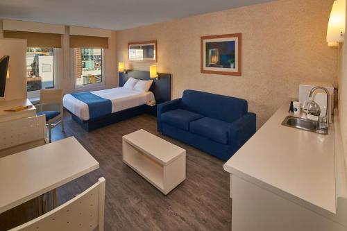 阿瓜斯卡连特斯阿瓜斯卡连特斯苏尔城市快捷酒店的酒店客房,配有床和蓝色的沙发