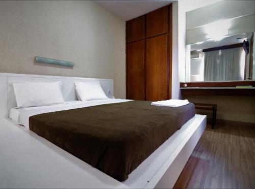 乌贝兰迪亚Grande Hotel Universo Palace的一间卧室配有一张带棕色毯子的大床
