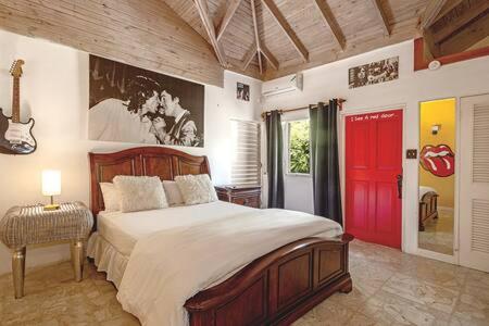 蒙特哥贝Hospitality Expert Jagger - Tour Pool Bar Beach的一间卧室设有一张大床和一扇红色的门