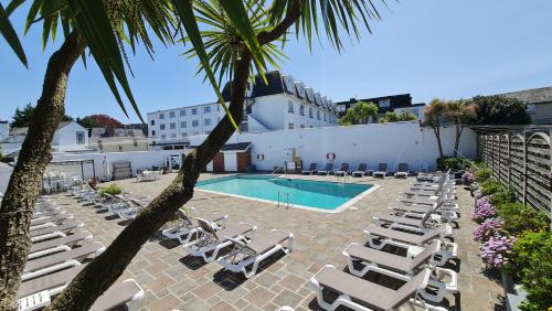 圣赫利尔泽西诺弗克酒店的一个带躺椅的游泳池以及度假村