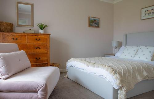 CulnacnocTaigh Mhurdaidh的一间卧室配有一张床、梳妆台和椅子