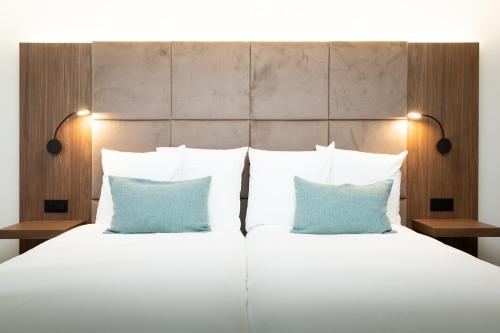 尼乌波特Dune Hotel Nieuwpoort的一间卧室配有一张带两个蓝色枕头的床