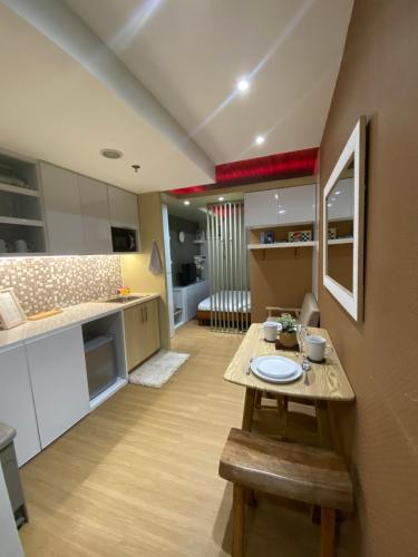 大雅台NA Suites at Pine Suites Tagaytay的厨房以及带木桌的起居室。
