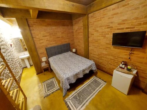 康塞高伊比蒂波卡IbitiAnJo - Suítes的小房间设有一张床和一台平面电视