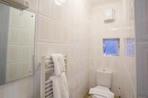 牛津巴特利酒店的白色的浴室设有卫生间和窗户。