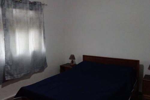 拉斯托斯卡斯Casa de playa para vacacionar的一间卧室设有蓝色的床和窗户。