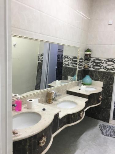 伊卜里Shakir house的一间带两个盥洗盆和大镜子的浴室