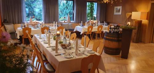 奥登瓦尔德斯特腾斯皮德布鲁曼法克杜酒店的一间设有白色桌椅的大型用餐室