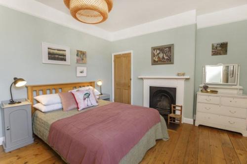 约克Minster House - Group Hot Tub的一间卧室设有一张大床和一个壁炉