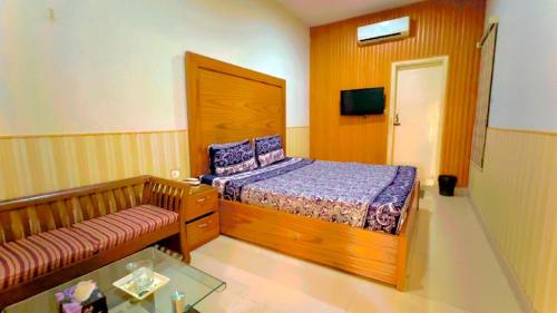 卡拉奇Best Couple Coprtive Guest House的一间带床和沙发的小卧室