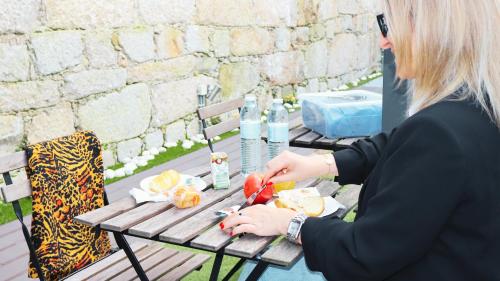 波尔图MyStay Porto São Bento的坐在野餐桌上吃食物的女人