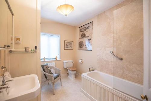 伍德布里奇Mole Cottage, Orford的带浴缸、卫生间和盥洗盆的浴室