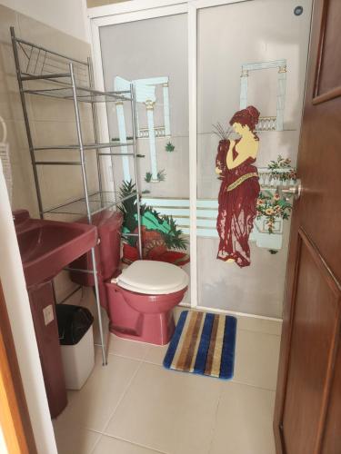 梅里达Casa de 3 recamaras frente al parque的一间带卫生间的浴室和一幅妇女画