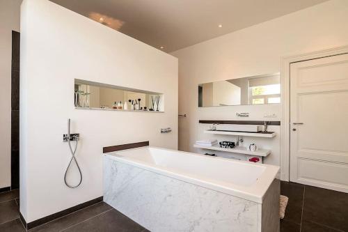 马斯特里赫特Bohemian Residence的白色的浴室设有浴缸和水槽。