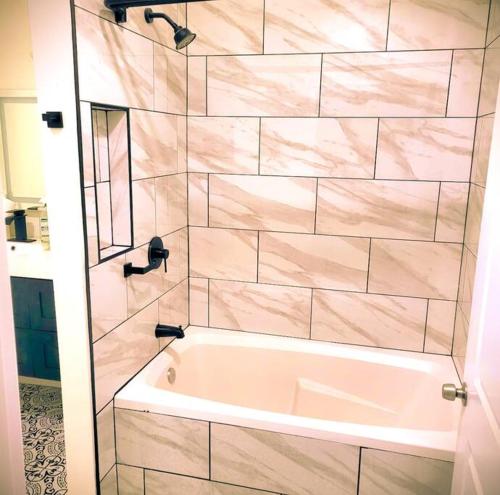 诺福克Beautiful Queen Luxury Suite Near Downtown Norfolk的浴室配有白色浴缸和镜子