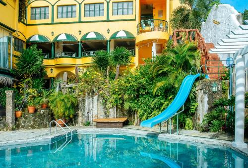 卡兰巴RedDoorz @ Yahweh Spring Retreat & Resort Laguna的大楼前带滑梯的游泳池