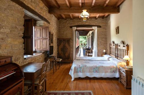 拉斯赫勒里亚斯Paraiso del Bierzo的卧室配有一张床和一张桌子及椅子