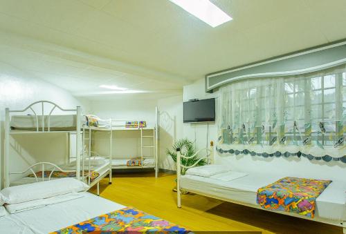 卡兰巴RedDoorz @ Yahweh Spring Retreat & Resort Laguna的客房设有两张双层床和一台平面电视。