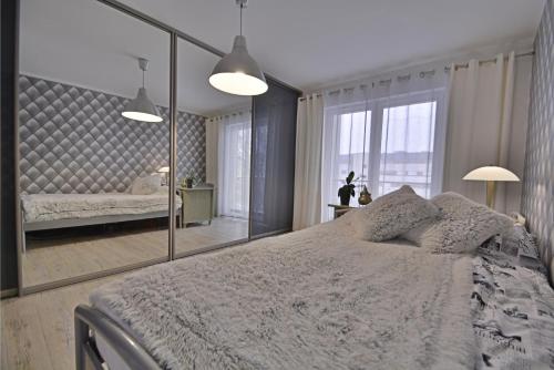 斯维诺乌伊希切Apartamenty Bryza - Debina的一间带大镜子和床的卧室