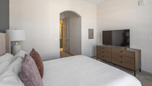 加兰Landing Modern Apartment with Amazing Amenities (ID8581X7)的一间卧室配有一张床和一台平面电视