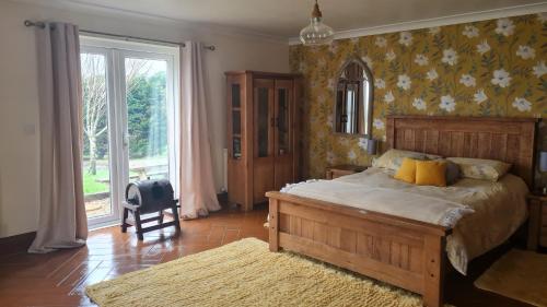 兰盖夫尼Romantic rural cottage, log burner, Sky tv early check in ,large gardens的一间卧室设有一张大床和一个大窗户