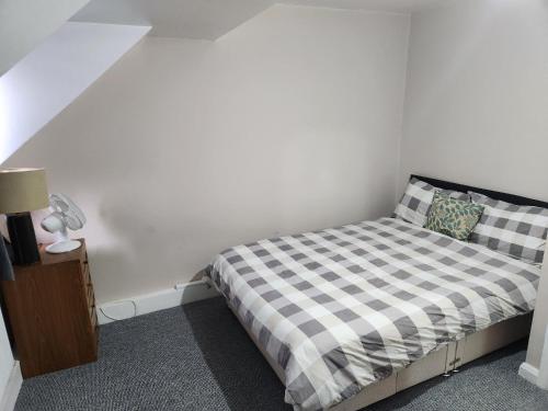 普拉姆斯特德Tuscawilla 2的小卧室配有一张带 ⁇ 子毯子的床