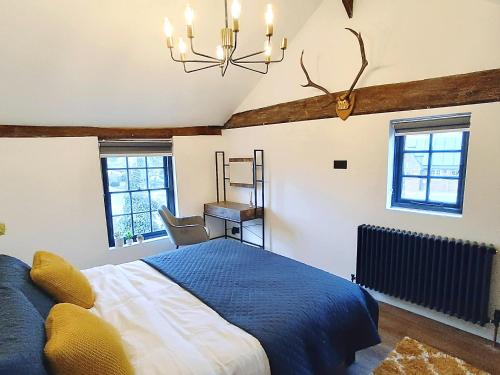 彼索普斯托福Stansted Airport Cottage的一间卧室配有蓝色的床和吊灯。